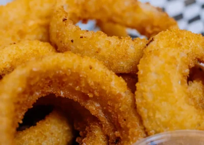 Close-up of crispy, breaded onion rings with dipping sauce