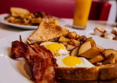 Diner breakfast plate with eggs, bacon, potatoes, and toast